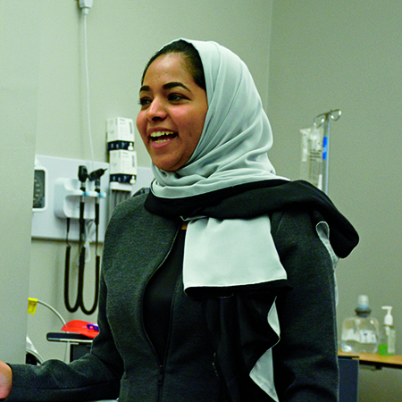 Ibtisam Almashni standing in the front of a classroom during a presentation.